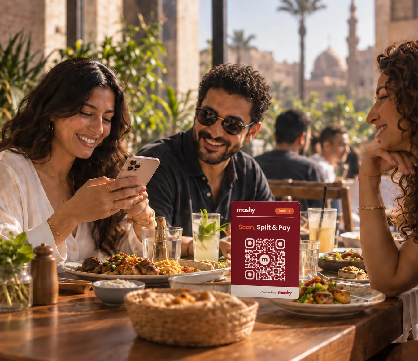 Friends enjoying a meal with a burgundy Mashy QR card on their table.